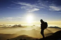 Hiker on mountain at sunset
