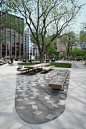 This may contain: an empty park with benches and trees in the foreground, surrounded by tall buildings