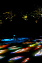 錦鯉舟楫共舞所描繪之水面圖──武雄池塘 / Drawing on the Water Surface Created by the Dance of Koi and Boats – Mifuneyama Rakuen Pond​ | teamLab : 装置艺术本身会随着漂浮在池面的小船前进而不断变化。而且鱼群整体本身并没有意志，而是每一尾鱼都会受到附近鱼群的影响，并以自律性的方式来游泳。当小船静静地飘浮在水面时，鱼群就会聚集到小船的周围，而当小船开始航行时，鱼群就会避开小船。鱼儿在游泳时会受到小船行动以