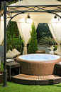 This hot tub with soft sides and extra seating is a comfortable piece for hosting a get-together in the warm water. The cloth domed gazebo above the hot tub has an elegant design, making this area more welcoming.