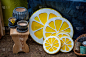 在节庆街上的集市上，出售手工制作的木制品：花盆、凳子、黄色柠檬形式的装饰品、烛台.