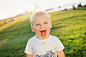 Little boy with chocolate face on green meadow, sunny summer