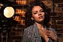 关闭了。肖像性感的海报模特在黑色内衣和格子夹克。聚光灯和棕色的砖墙作为背景。