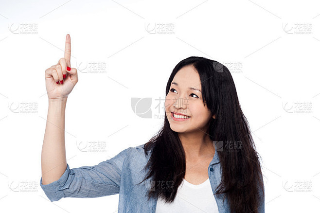 漂亮的女孩看着并指着上面