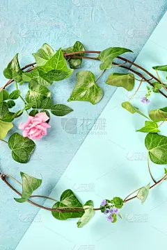 邀请或贺卡设计模板。一个由树叶和鲜花组成的扁平花环，在带有copyspace的蓝色背景上从顶部拍摄。