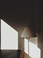 white and gray floor lamp beside wall