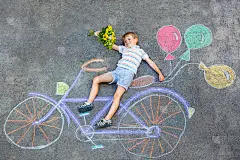 小男孩玩自行车粉笔画在地上