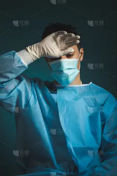 疲惫的医生辛苦工作几个小时后，与冠状病毒患者的重症监护。被摧毁和精神枯竭的医生。空视图。年轻医生穿着