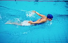 Woman in pool, swimming butterfly strokeWoman in pool, swimming butterfly stroke