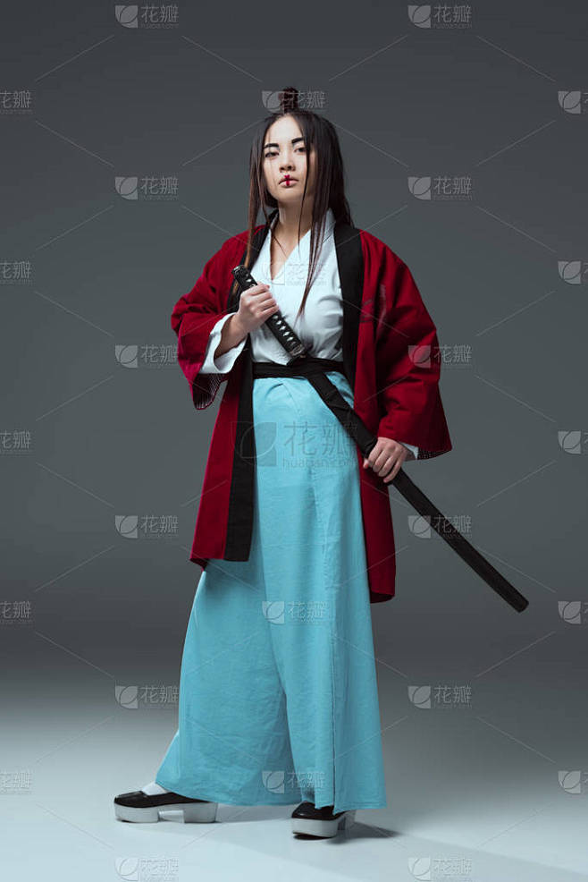 武士在和服手持武士刀剑和看在灰色的照相机