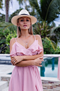 Portrait of caucasian woman in romantic elegant pink long dress on vacation at luxury rich villa hotel with amazing tropical palm trees view female in classic white hat
