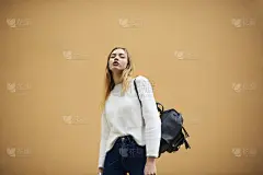 半长Vogue肖像迷人的潮人女孩时尚的背包穿着休闲装看着相机与广告或促销内容的复制空间区域的背景