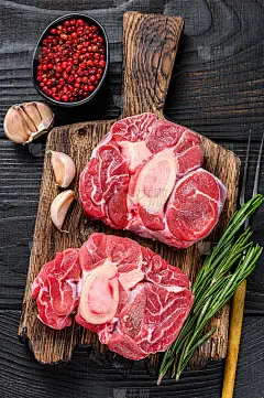 生肉烩牛膝小牛肉小腿牛排，做意大利烩牛膝。黑色木制背景。俯视图
