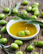 Fresh green olives with leaves and olive oil on wooden backgroun by Anjelika Gretskaia on 500px