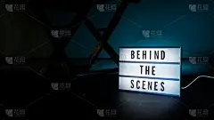 幕后灯箱。电影灯箱上的文字。扩音器，导演椅和电影石板旁边。领导的背景颜色。摄像机在视频制作工作室。幕