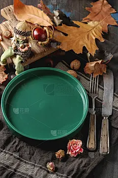 为万圣节装饰。秋天的名片。绿色盘子，栗子，坚果，叶子。自由空间的文本。