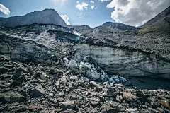 风景优美的高地景观与大开裂的冰川，冰碛石之间的划痕在高山峰的背景阳光。壮观的山景，巨大的冰川和伟大的
