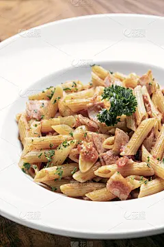 木桌背景上放着通心粉、阿马特里西酱、番茄和火腿酱意大利面