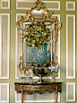 A shimmery gingko-leaf wreath and rococo mirror hang above an early 19th-century console table, where a large antique silver urn chills wine. Love the moldings too!
洛可可风格