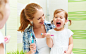 happy family mother and child girl cleans teeth with toothbrush