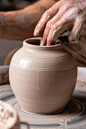 陶工在工作室里用白色粘土在轮子上做一个罐子或罐子。创意、艺术和手工的概念照片摄影图片