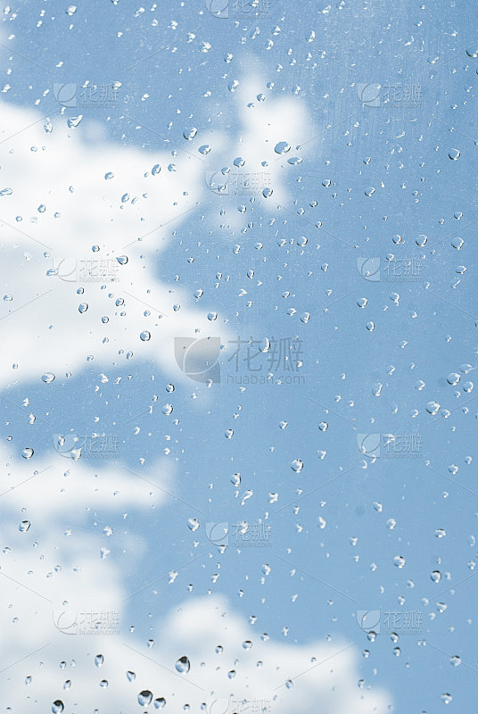 雨点落在窗玻璃上，点缀着蓝天白云