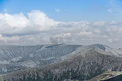 在蓝色多云的天空下的地平线上的岩石脊。山谷旅行。探险旅游、旅游保护理念。