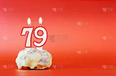 七十九岁生日。纸杯蛋糕，上面有燃烧着的79号白色蜡烛。鲜艳的红色背景与复制空间