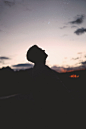 silhouette of man wearing hat during night time