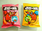 two bags of food sitting on top of a white table next to each other,