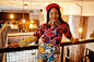 Enthusiastic african american woman in trendy coloured outfit with red beret chilling in cozy cafe