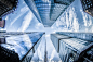 Low-angle Photo of Four High-rise Curtain Wall Buildings Under White Clouds and Blue Sky