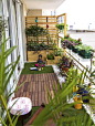 A small balcony has been converted into an oasis by adding lots of plants in wooden containers, ceramic pots, railing planters, etc. There is still enough place for the family to sit outside and spend time alone or with each other.: 