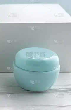 蓝色的乳霜容器和白色的盒子放在白色的桌子上