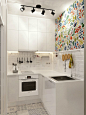 The reflective white flat-panel cabinets make this space feel airier, the backsplash resembling a brick wall is painted in pure white, but in order to enliven this area, a splash of color was added through a multi-color wall floral pattern placed just abo