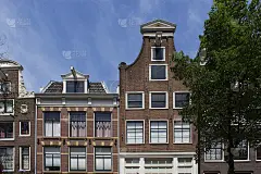 阿姆斯特丹的历史、传统和典型建筑展示了荷兰的建筑风格和一棵树。这是一个阳光明媚的夏日。