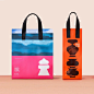 This may contain: two shopping bags sitting on top of a table next to each other with different designs
