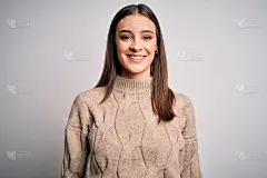 年轻美丽的黑发女人穿着休闲毛衣站在白色的背景与快乐和凉爽的微笑在脸上。幸运的人。
