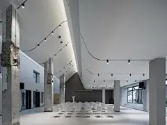 昆山计家墩村会议中心 建筑设计 / 严旸建筑设计工作室 : 项目位于昆山锦溪计家墩村，曾经为村委办公大楼，后经改造作为“村民”的公共活动空间。承载餐饮、展示与接待功能。一楼为展示、接待等功能、二楼则作为餐厅在使用。如今因为功能使用调整，场所将重新进行改造与更新。建筑师接到任务时，使用方要求建筑上不要做太大的拆改，希望能够在满足所需功能及美学的前提下最大化利用原有材质及墙体。在勘查场地后建筑师对于原有建筑多处既内且外、既彼又此及所营造的室内与室外交织、建筑与...