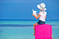 Little adorable girl with big pink suitcase and map of island on white beach by Dmitry Travnikov on 500px
