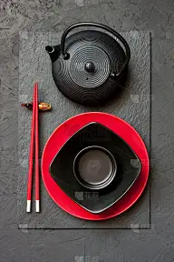 深色的桌子上放着陶瓷盘子和筷子