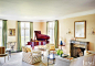 Traditional Yellow Living Room with Brick Fireplace : The light-filled living room of this Lake Forest home features a Holly Hunt sofa and a pair of chairs by Dessin Fournir swathed in Raoul Textiles fabric.