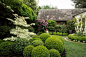 Pruned boxwood and variegated dogwood are featured in this landscape that uses features from classic Italian and French design elements.  by Hoi Ning Wong