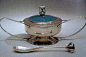 阿什比(Charles R。Ashbee1863-1942)是一位有天分和创造性的银匠，主要设计金属器皿，这些器皿一般用榔头锻打成型，并饰以宝石，能反映出手工艺金属制品的共同特点。
在他的设计中，采用了各种纤细、起伏的线条，被认为是新艺术的先声。
1888年由阿什比组建的“手工艺行会” , 1908年以失败而告终。 