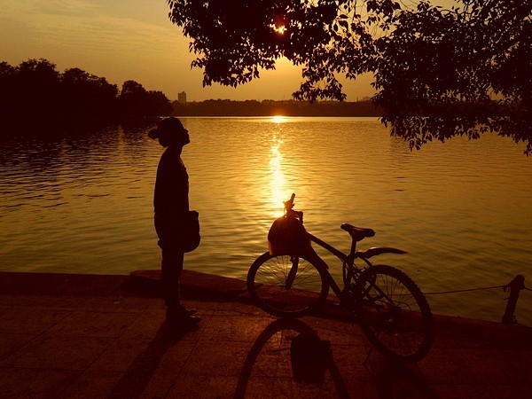 和表妹傍晚逛公园 在湖边看到夕阳下的自行...