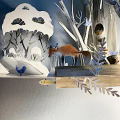 将插画与剪纸艺术结合起来，运用综合材料将原本平面的插画变成了三维的空间，创作了美丽的童话世界。

我们可以看到作者在布置场景时不仅有前后虚实的处理，还会搭配灯光效果，营造整体的氛围，能够感受到小森林里，光从树叶的间隙透过，投射到地上，光影斑驳，让人看得想进入到作者搭建的那个童话之境里~
