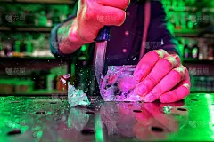 近距离的酒保压碎一大块冰在吧台上与一个特殊的酒吧设备在它为鸡尾酒