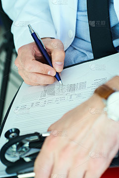男值班医生白大褂手持笔填写处方或检查表文件关闭。择笔专注，健康医学理念。