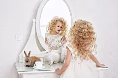 Little beautiful and cute girl child in a fashionable festive dress and with animals rabbits in the mirror in a white interiorLittle beautiful and cute girl child in a fashionable festive dress and with animals rabbits in the mirror in a white interior