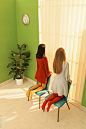 two young woman in front of window with jalouise by ulas & merve for Stocksy United